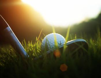 close up on golf ball and club 