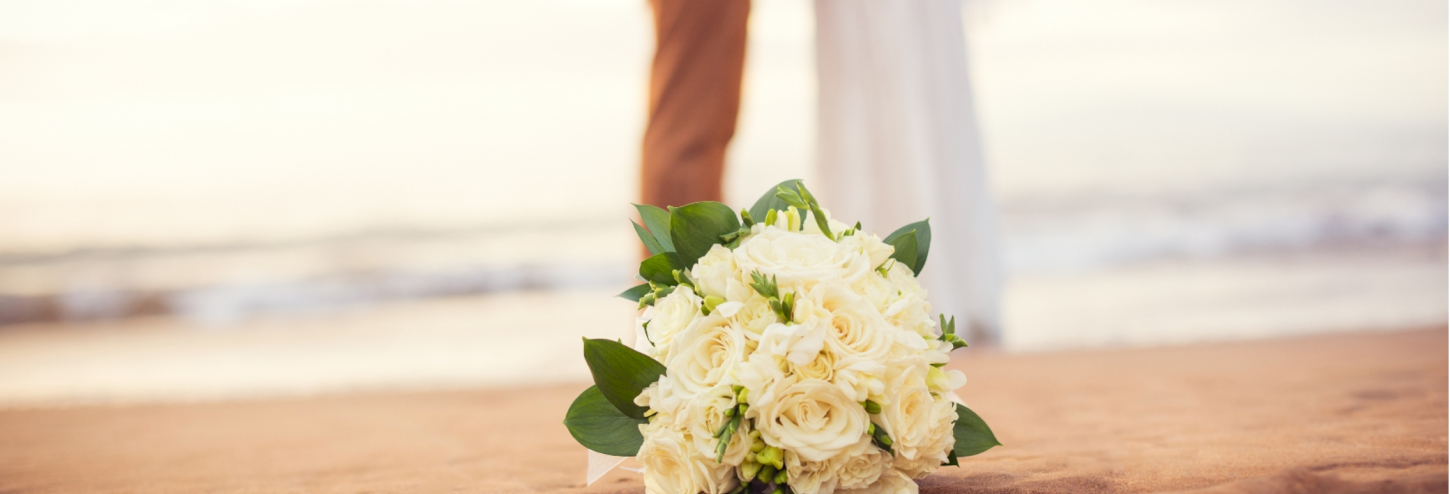 A bouquet in a bride's right hand during her wedding in Poipu Beach